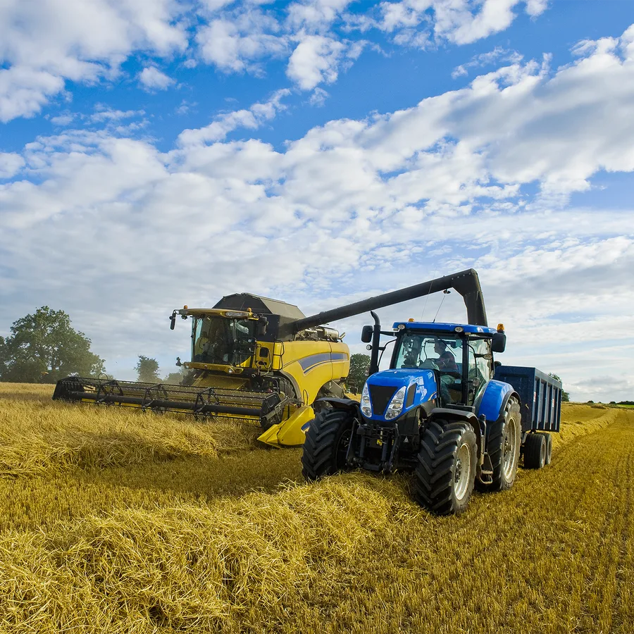 Combine harvester and tractor working a field at harvest